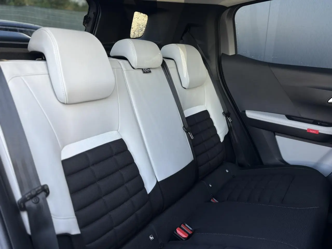 Vue latérale des sièges arrière bicolores noir et blanc du Citroën C3 Aircross 2025 avec garniture textile et appuis-tête intégrés.