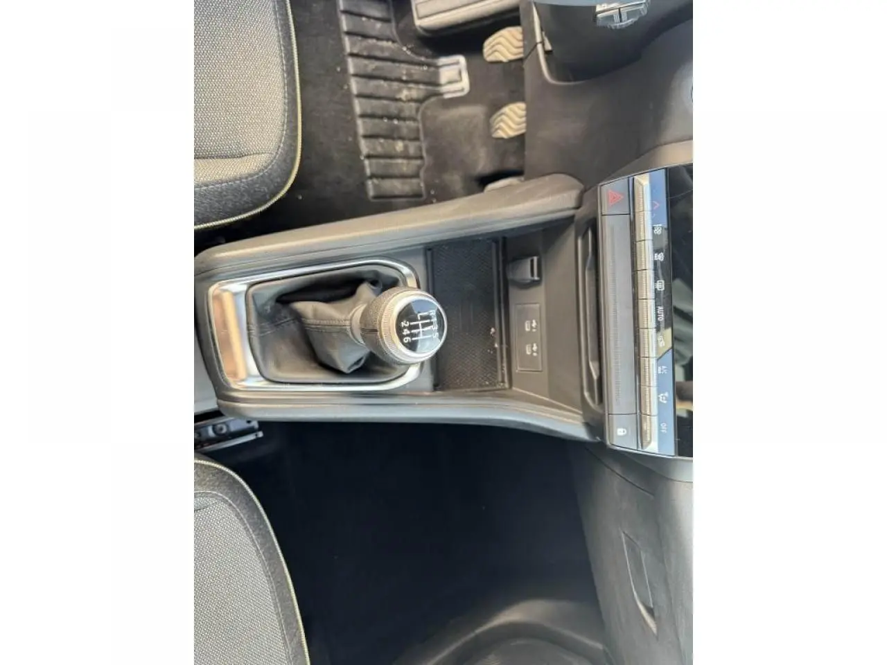 Vue plongeante sur la console centrale et levier de vitesses manuelle du Renault Captur II, intérieur noir.