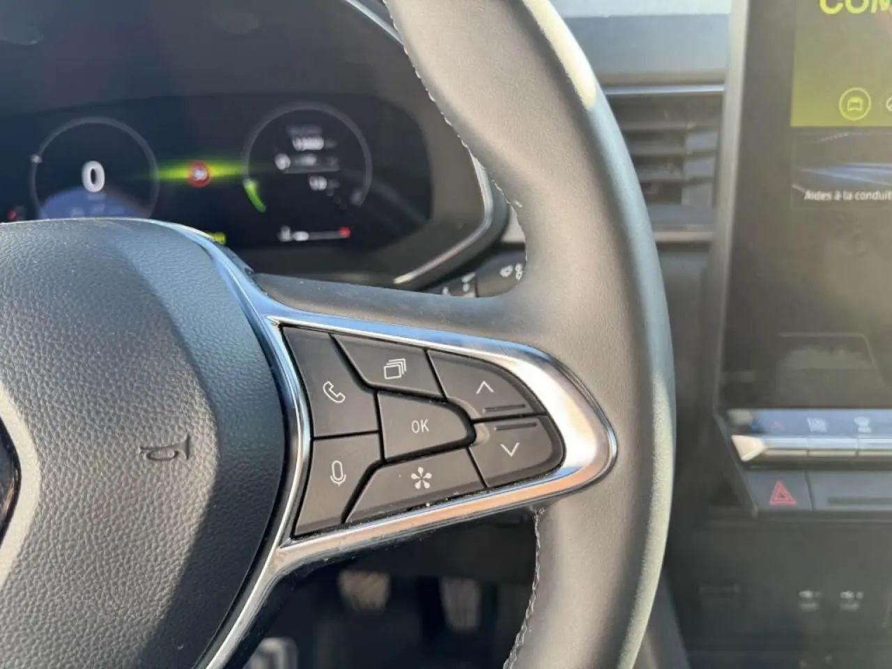 Gros plan sur le volant côté droit du Renault Captur II 2025 avec commandes intégrées et tableau de bord numérique flou.