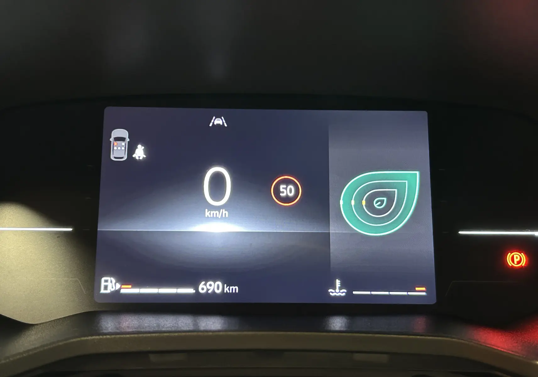 Tableau de bord numérique de Renault Clio V blanc, affichant 0 km/h, limite 50 km/h et autonomie 690 km.