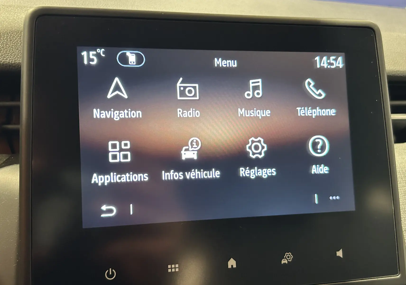 Écran tactile central de la Renault Clio V blanc affichant le menu principal avec navigation, radio et téléphone.