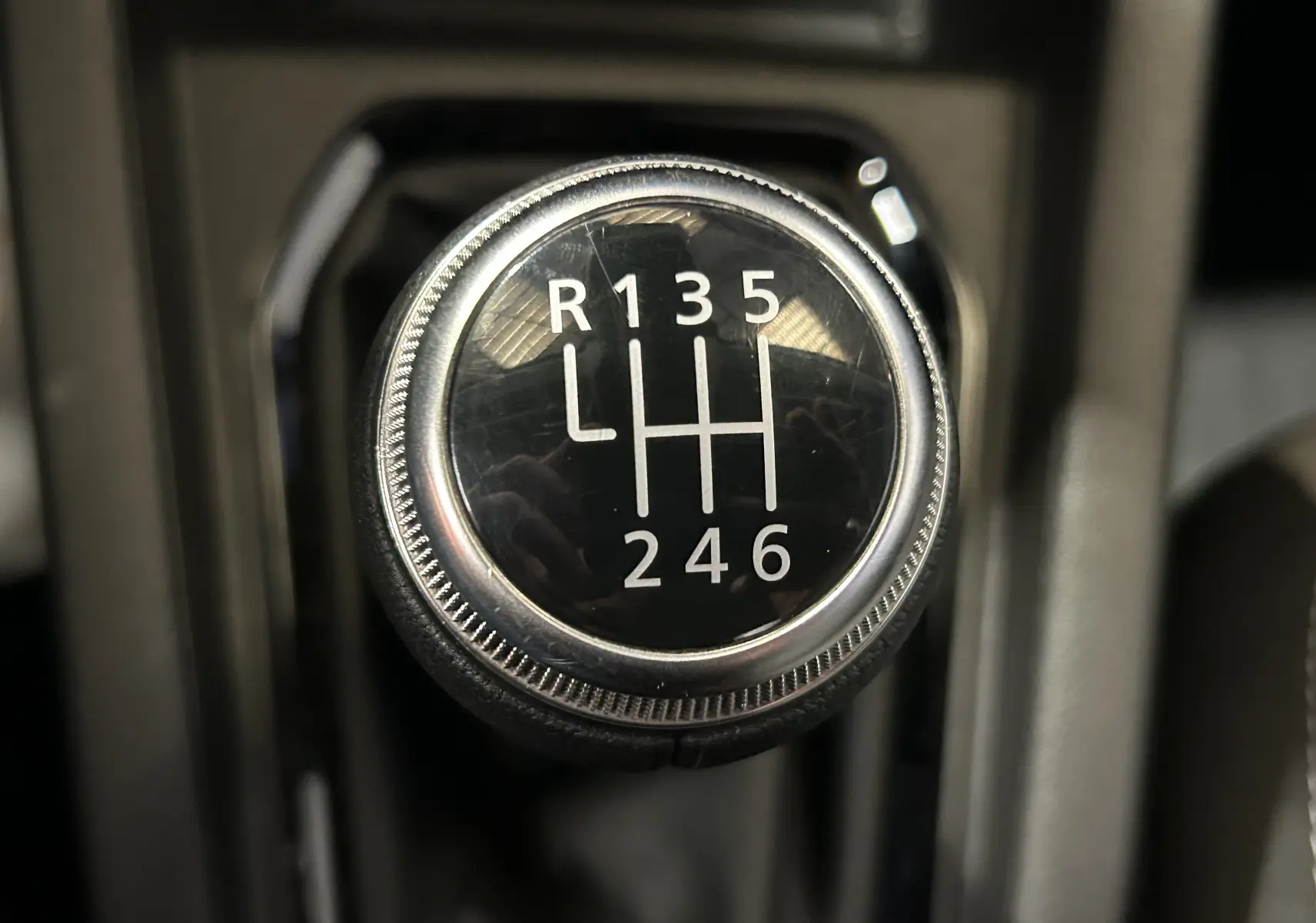 Gros plan sur le pommeau de la boîte manuelle 6 vitesses de la Renault Clio V, intérieur noir.