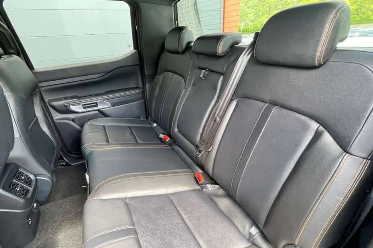 Vue latérale intérieure sur la banquette arrière en cuir noir avec surpiqûres contrastantes du Ford Ranger Wildtrak 2025.