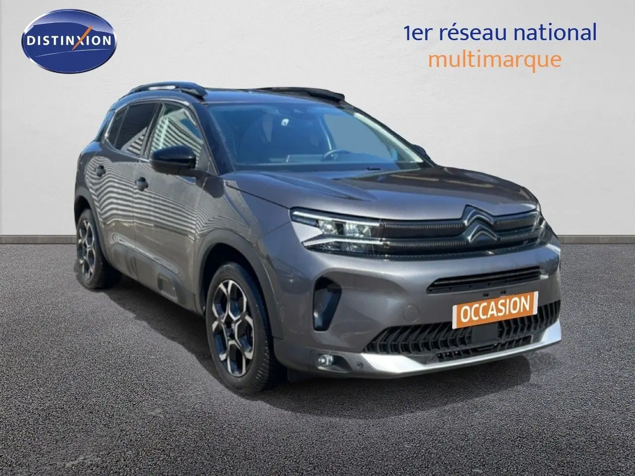 Vue 3/4 avant d'un Citroën C5 Aircross gris platinium métal avec jantes bi-ton et calandre distinctive.