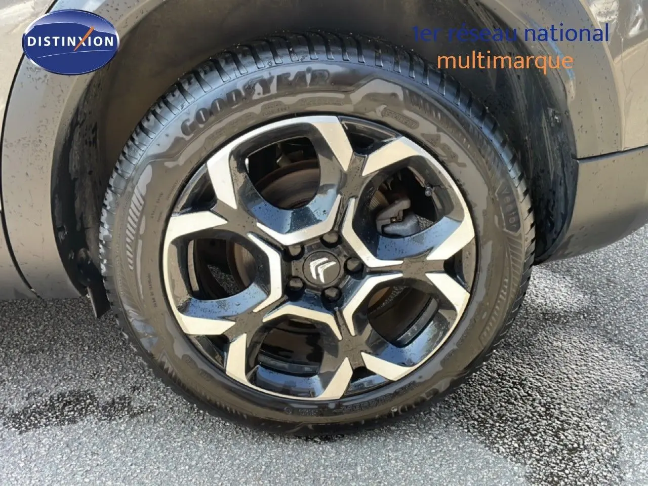 Gros plan sur la jante noire et argentée d’un Citroën C5 Aircross gris platinium, roue avant droite visible.