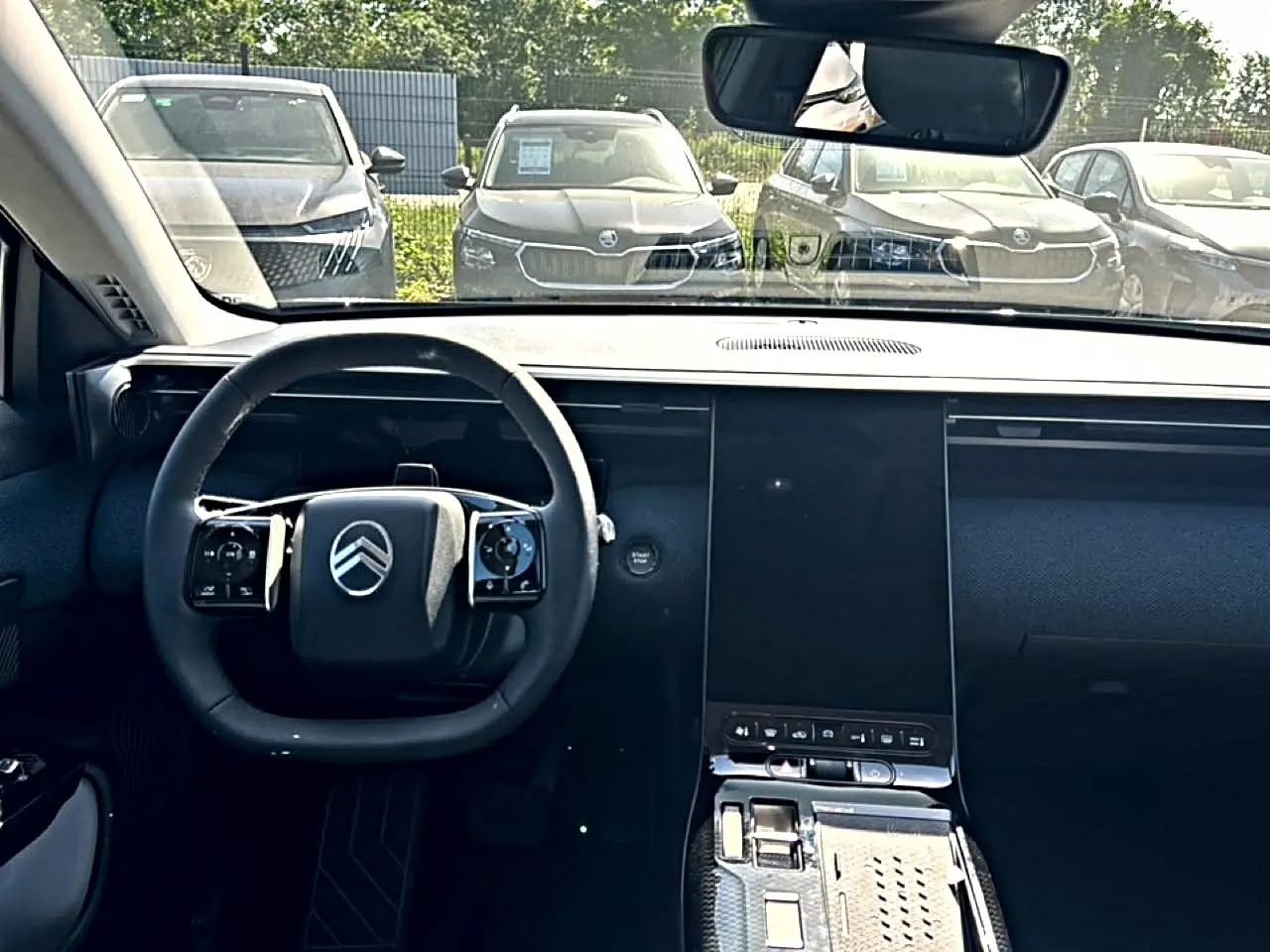 Vue intérieure frontale du tableau de bord et volant noir du Citroën C5 Aircross hybride 2026 avec écran tactile vertical.
