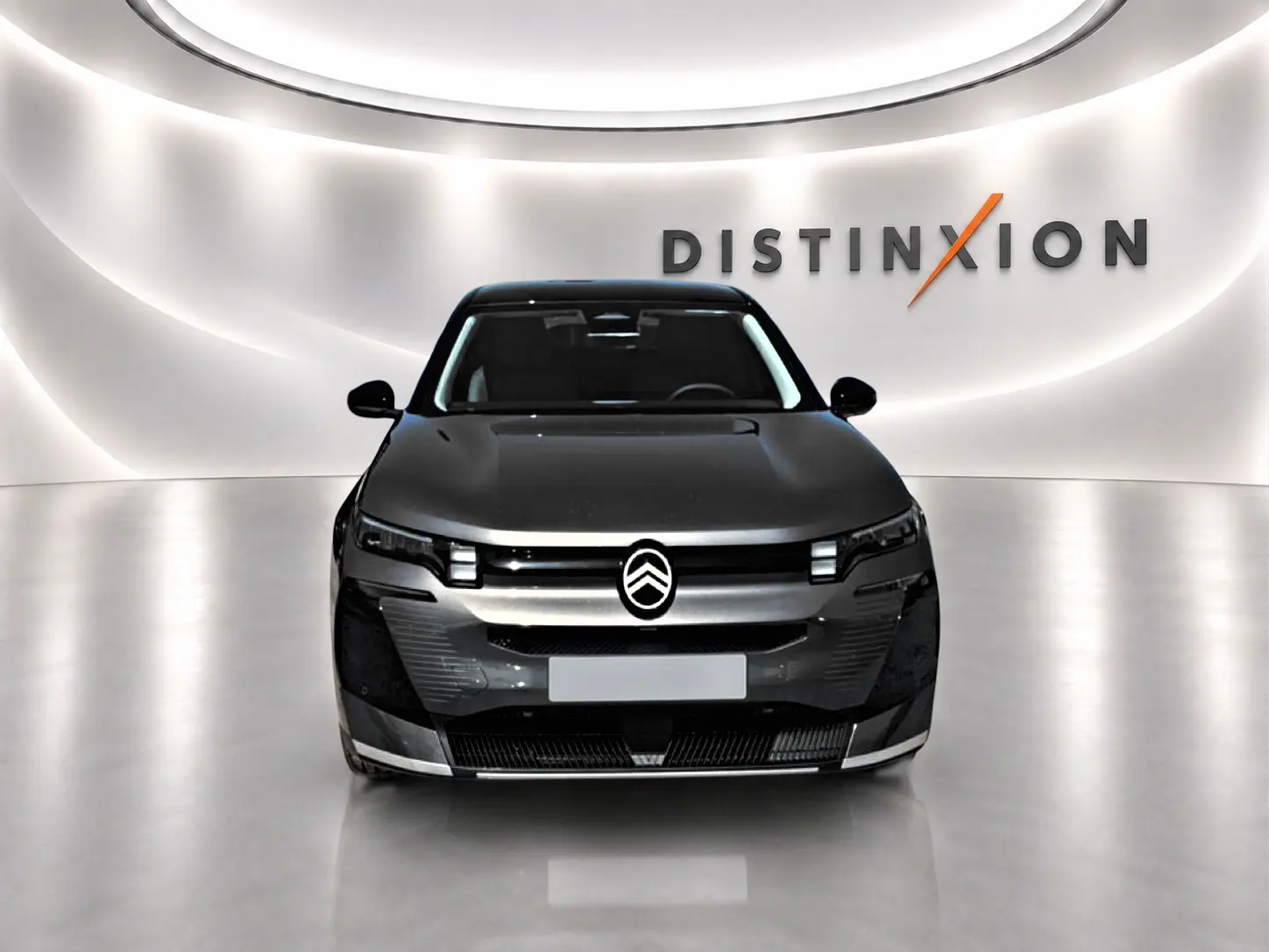 Citroën C5 Aircross gris platinium vue de face, avec toit noir et logo distinctif sur fond lumineux "Distinxion".