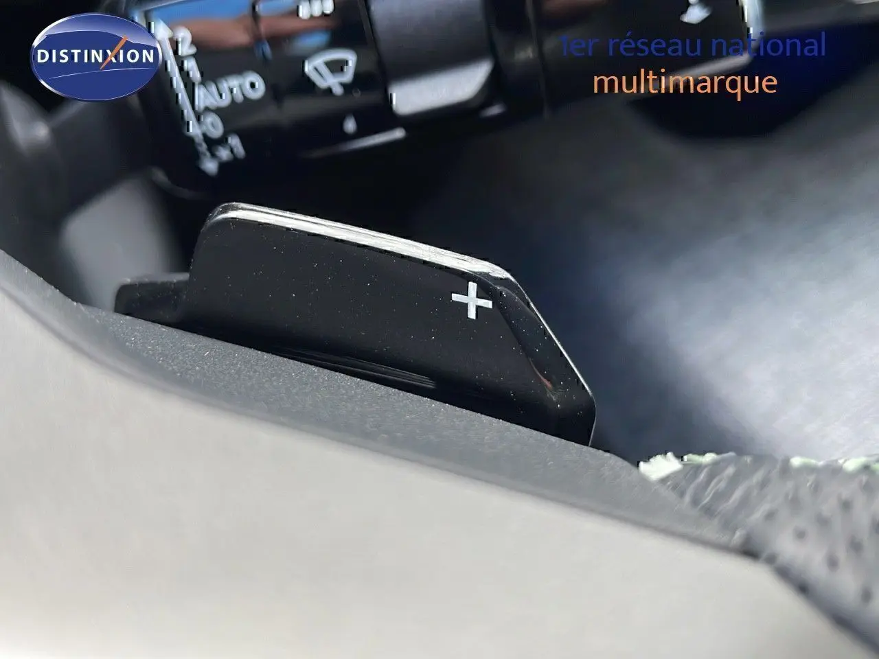Gros plan sur la palette de changement de vitesse "+" côté droit du volant du Peugeot 3008 hybride 2025.