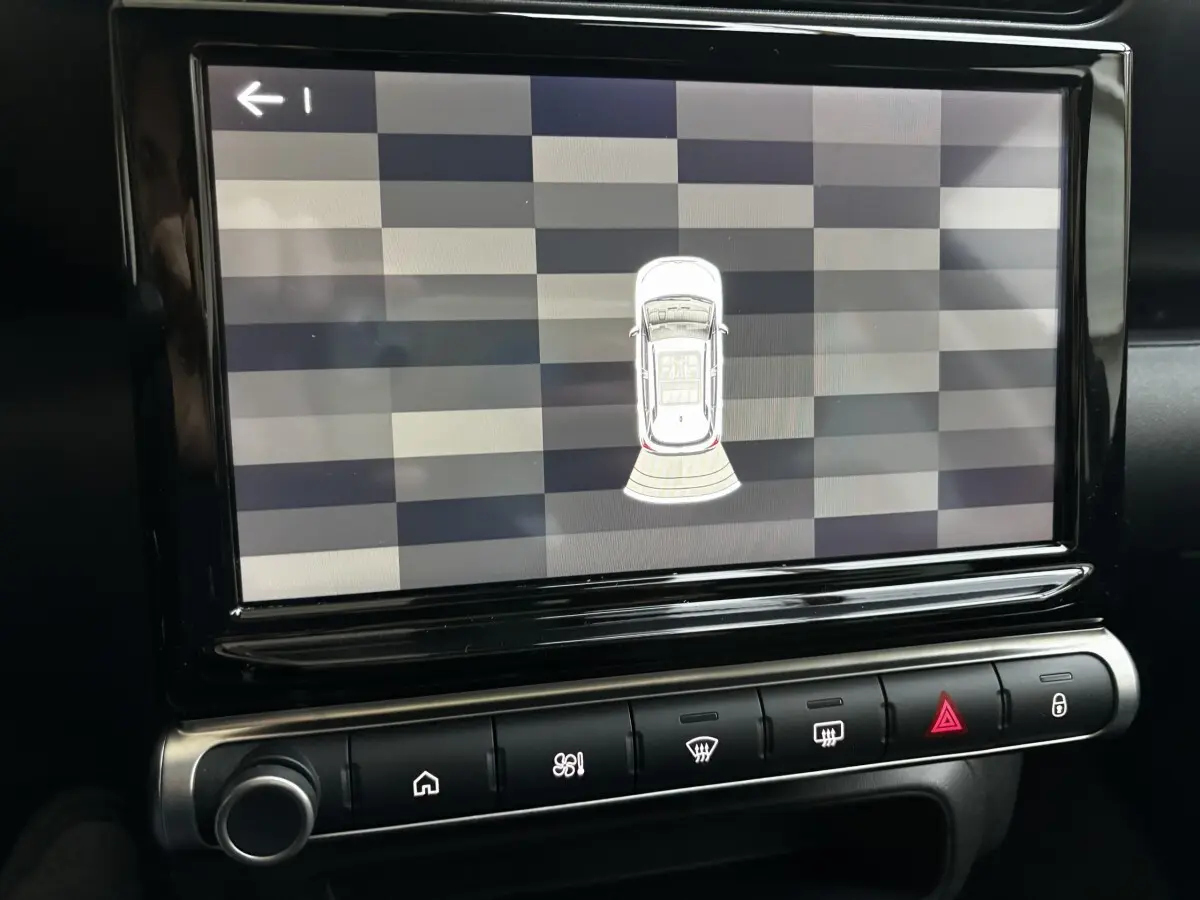 Écran tactile central du tableau de bord du Citroën C3 Aircross gris clair, affichant l'aide au stationnement en vue aérienne.