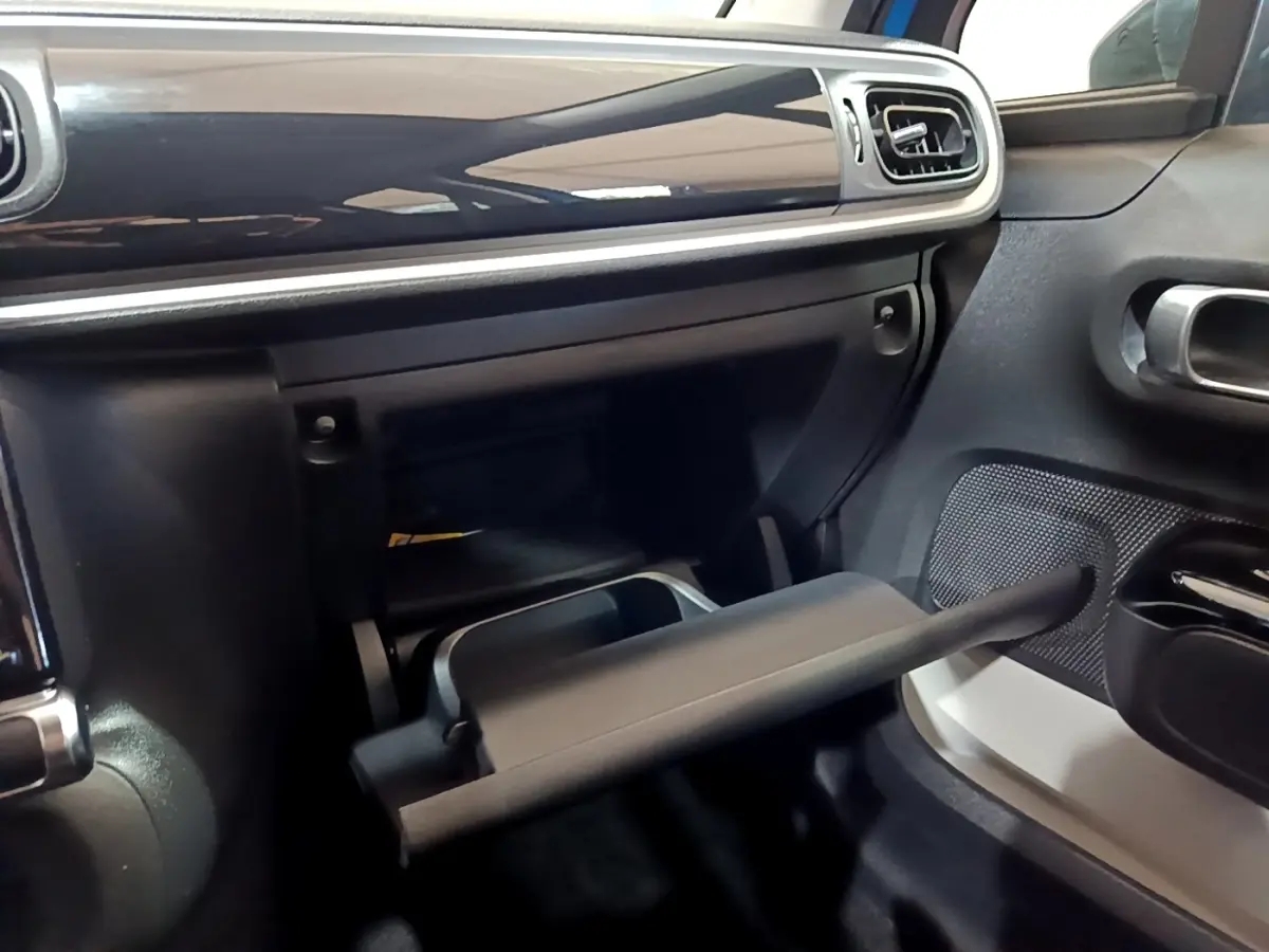 Intérieur de la Citroën C3 2017, vue du coffre à gants ouvert côté passager avec finition noire et détails argentés.