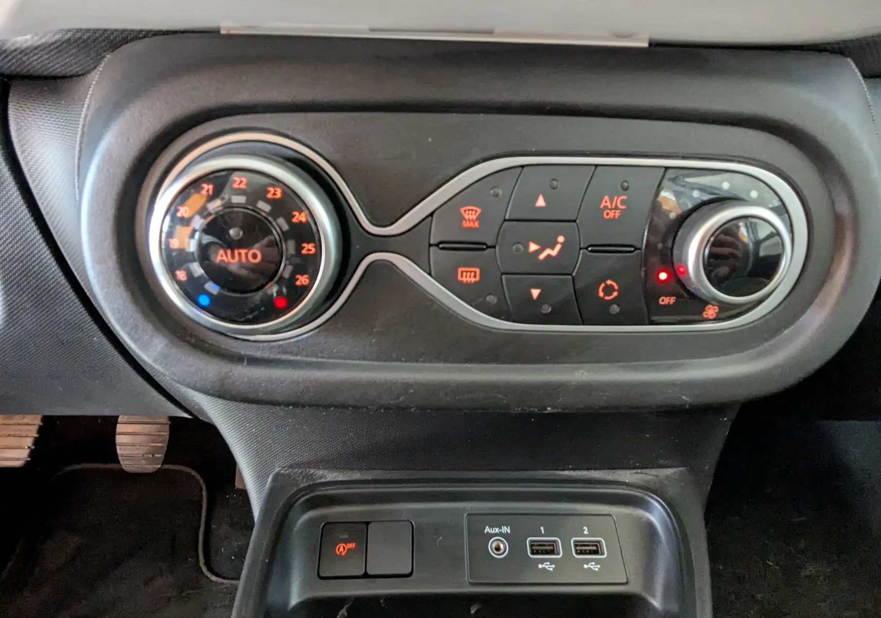 Vue rapprochée du tableau de bord de la Renault Twingo III 1.0 SCE 65 Limited, montrant les commandes de climatisation et les ports USB.