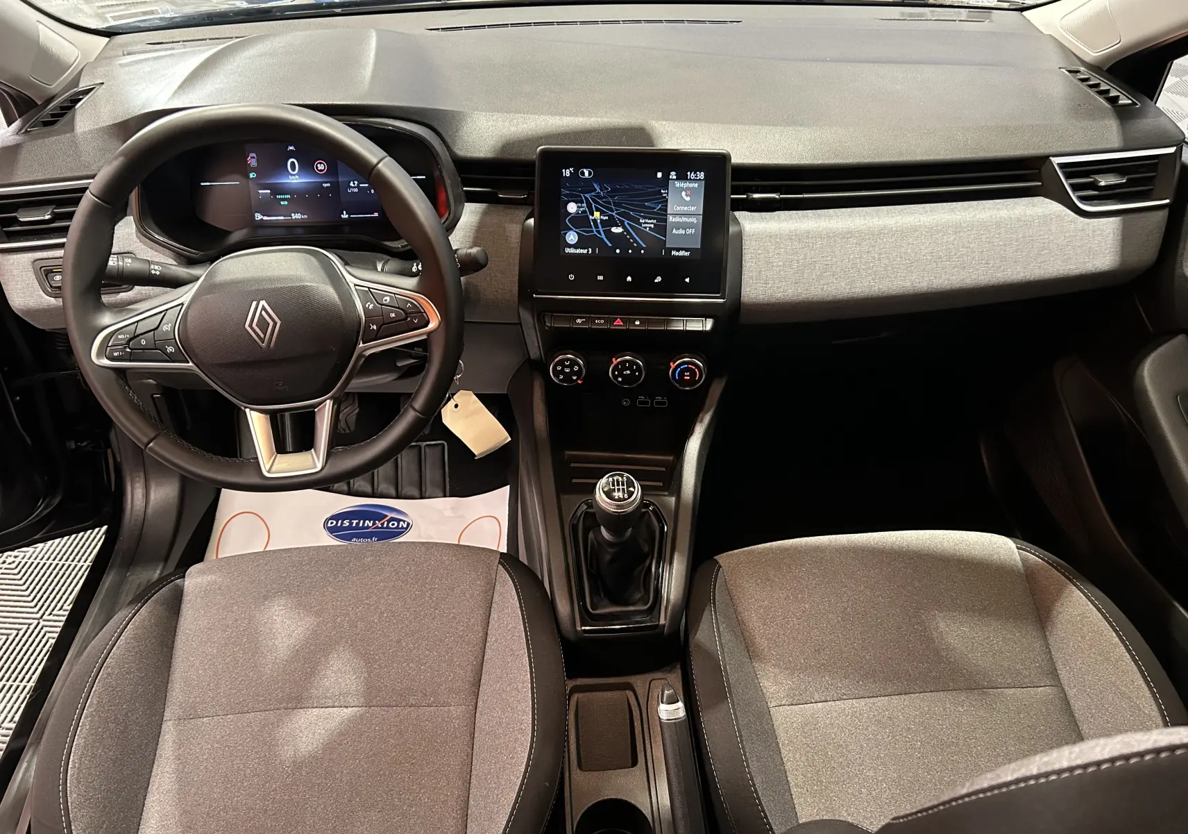 Vue intérieure avant de la Renault Clio V BluedCi 100 Evolution avec tableau de bord gris et volant multifonction noir.