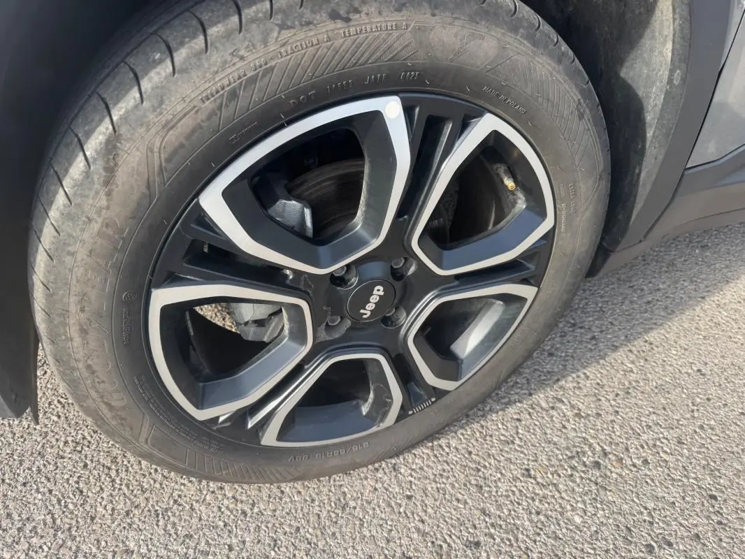 Gros plan sur la roue avant droite du Jeep Avenger gris 2025, jante alliage noire et argentée au design moderne.