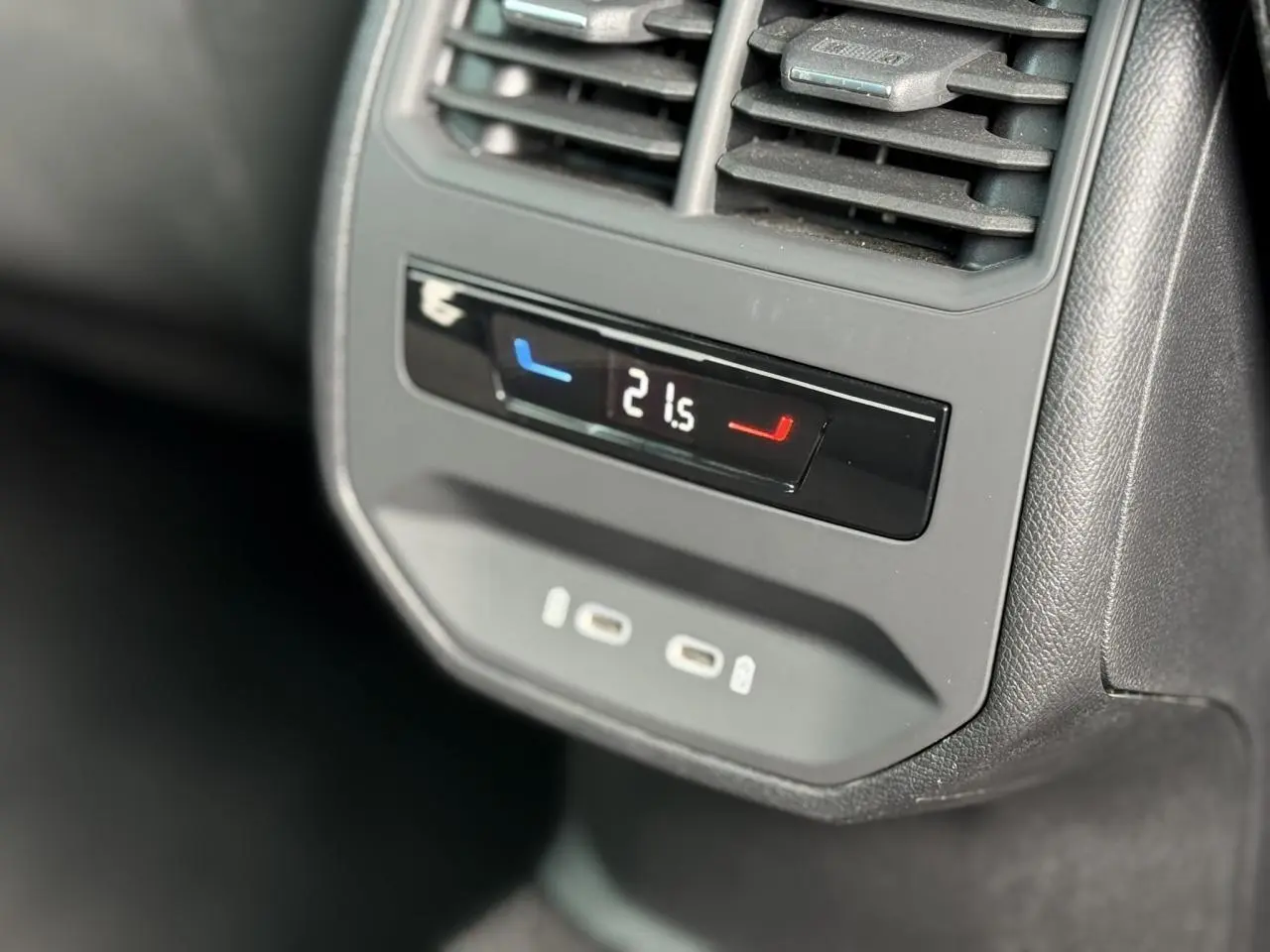 Détail du panneau de climatisation arrière avec affichage digital et prises USB-C dans une SEAT Leon blanche.