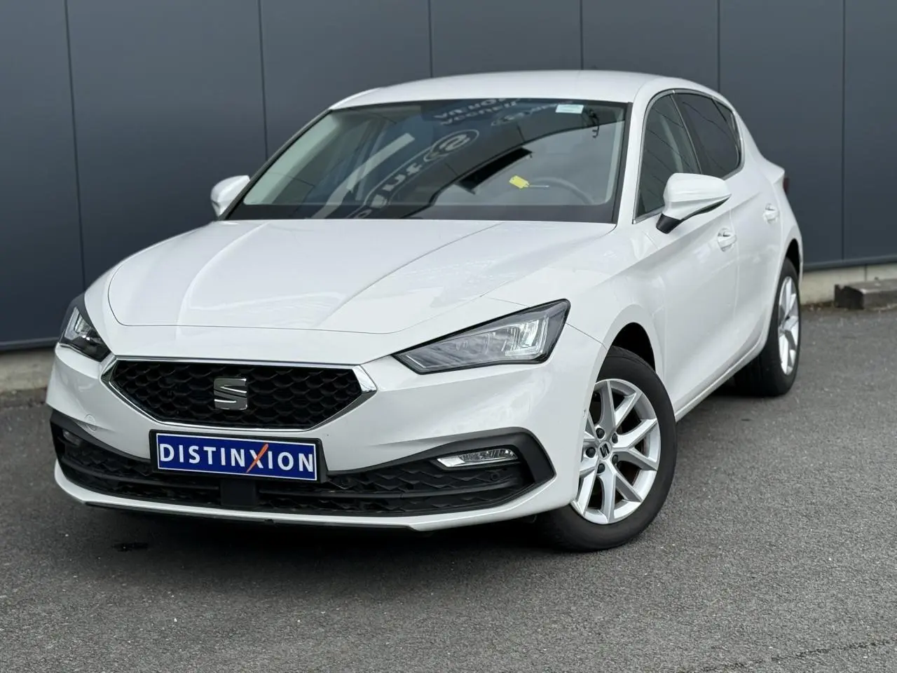 SEAT Leon blanc vue 3/4 avant droit, avec calandre noire et jantes alliage 16 pouces visibles.