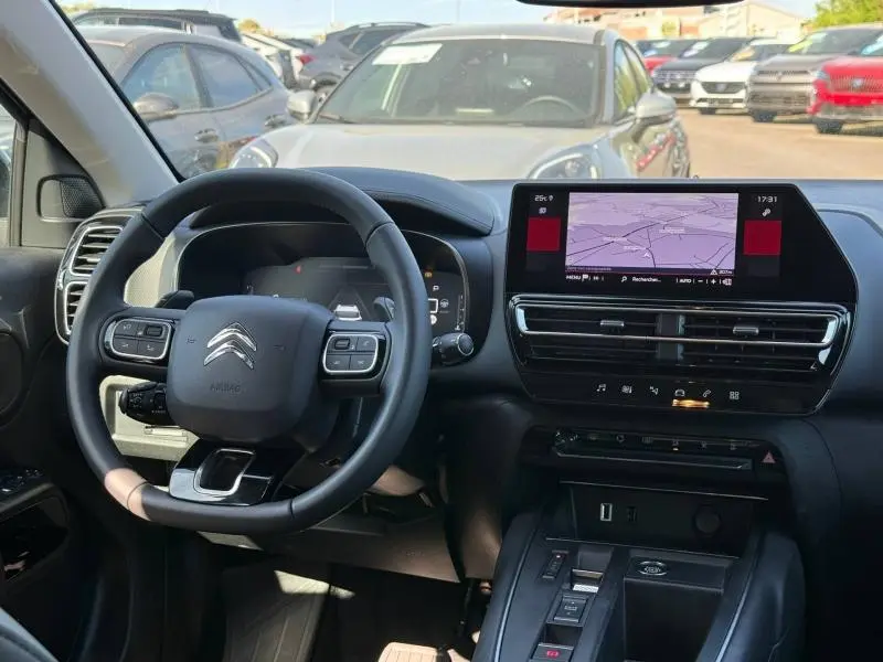 Intérieur du Citroën C5 Aircross 2025, vue du tableau de bord noir avec écran tactile GPS et volant multifonction.