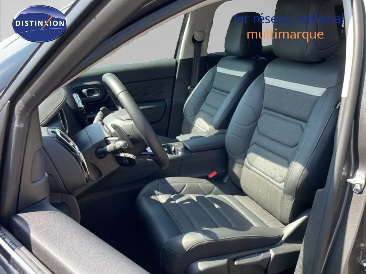 Vue intérieure côté conducteur du Citroën C5 Aircross gris platinium, sièges cuir tissu gris avec volant multifonction.