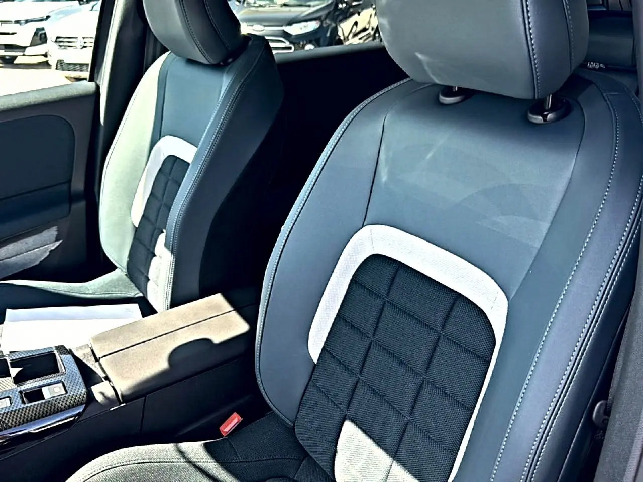 Gros plan sur les sièges avant bi-ton gris et noir du Citroën C5 Aircross 2026 avec accoudoir central et console.