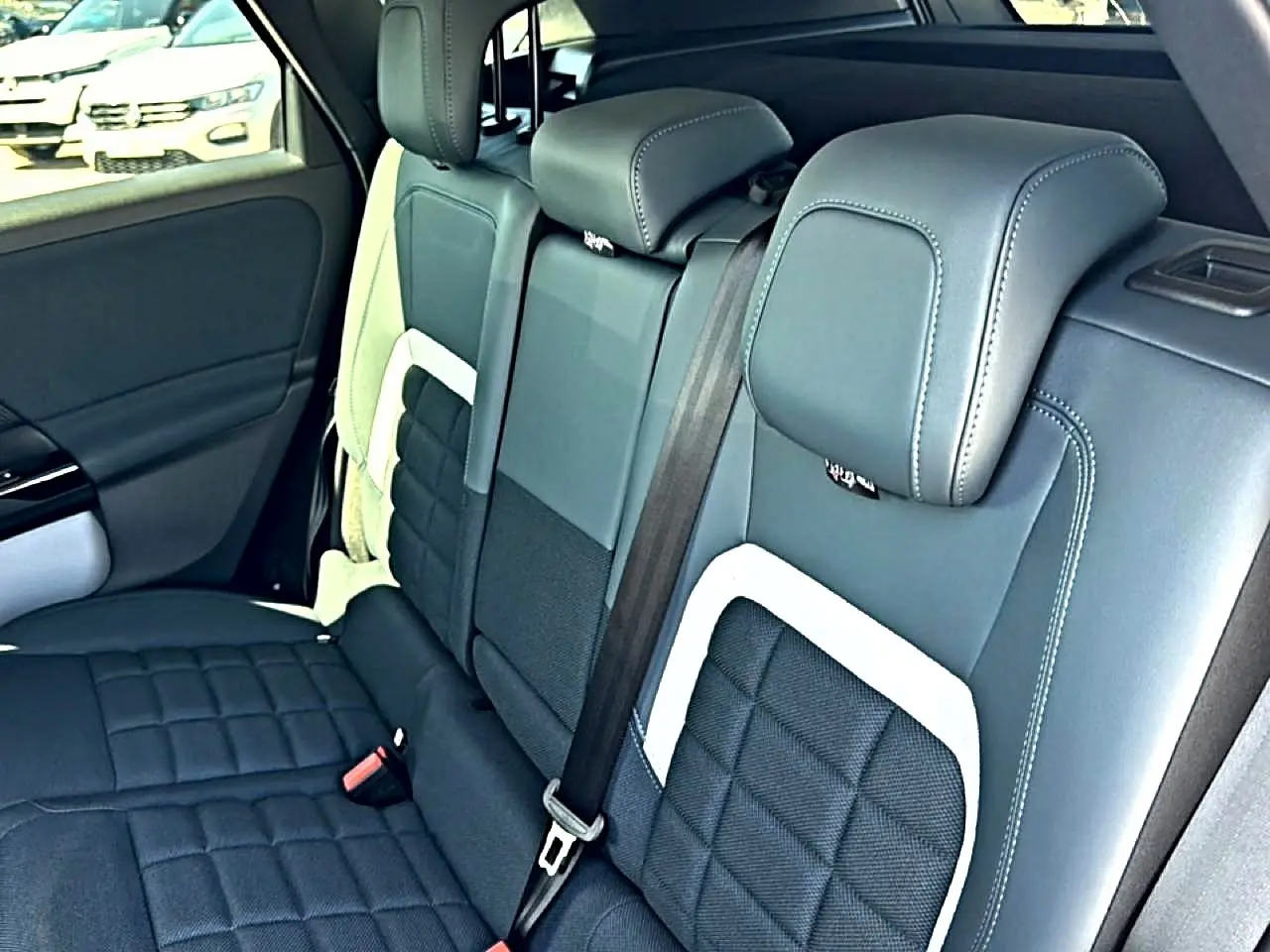 Vue intérieure de la banquette arrière en cuir noir et gris du Citroën C5 Aircross hybride 2026, avec ceinture de sécurité visible.