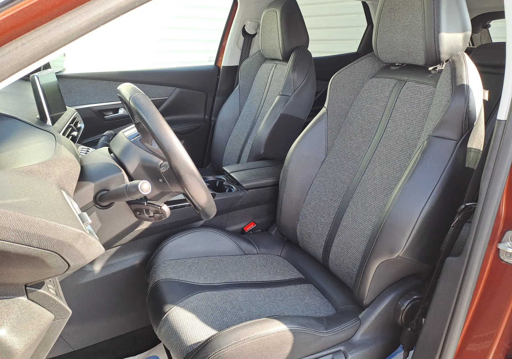 Vue intérieure côté conducteur du Peugeot 3008 2019 Metallic Cooper, sièges tissu et cuir gris avec volant noir.