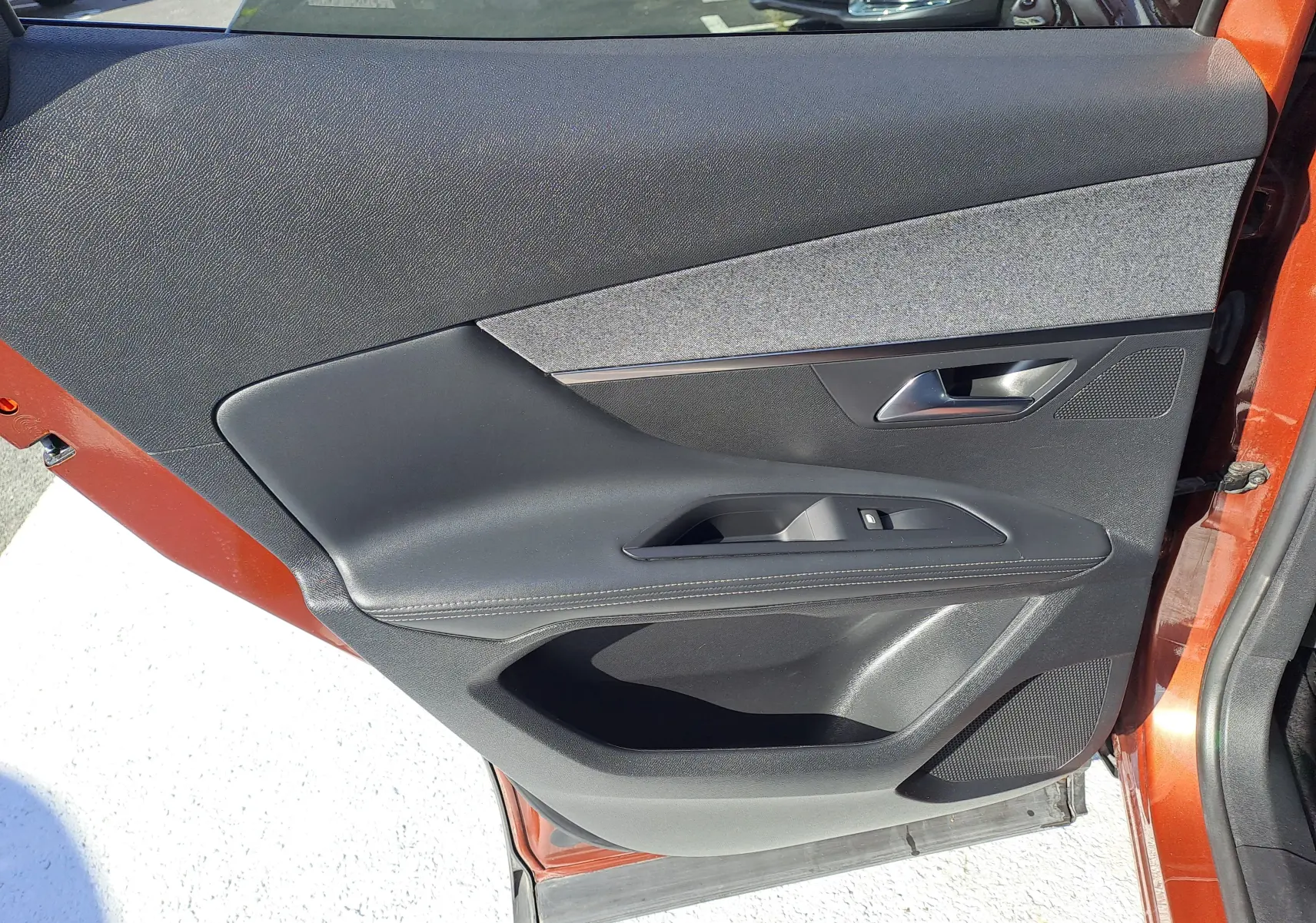 Intérieur de la porte côté gauche du Peugeot 3008 2019 Metallic Cooper, avec garniture noire et tissu gris.