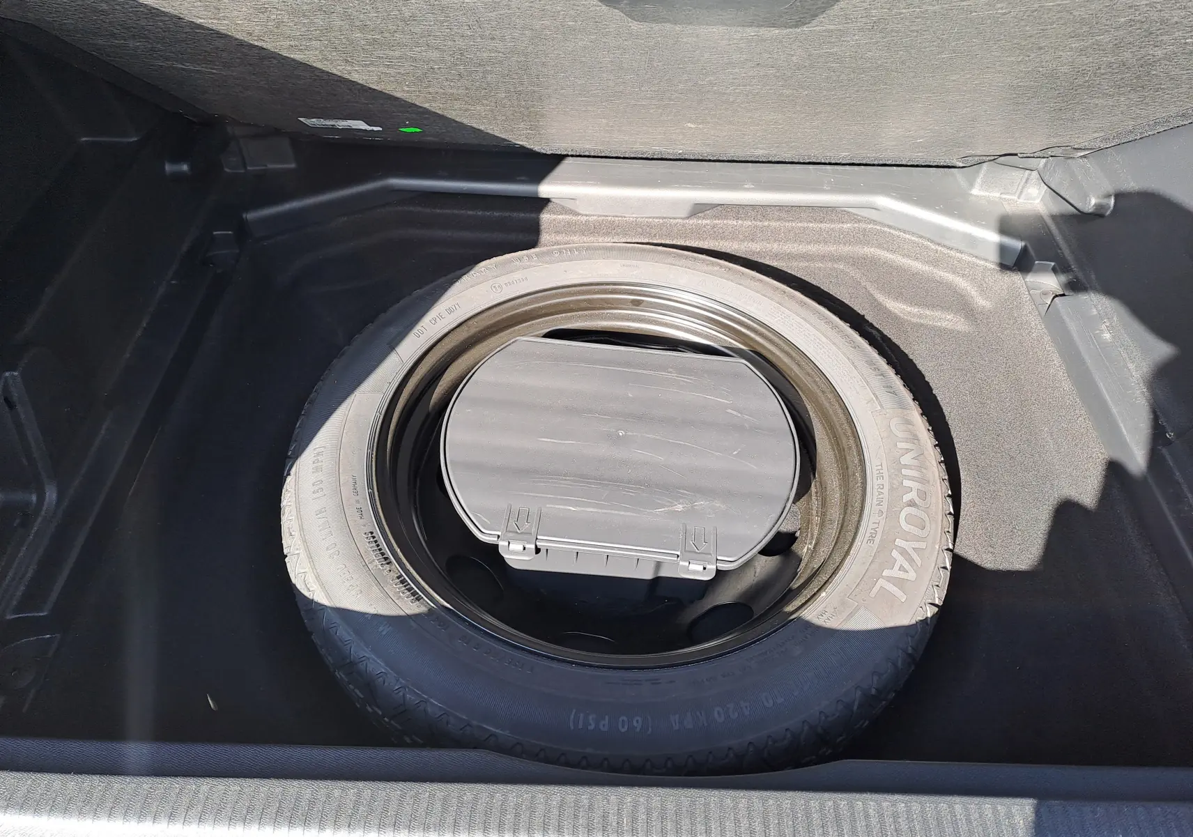 Pneu de secours Uniroyal dans le coffre du Peugeot 3008 2019 couleur Metallic Cooper, vue intérieure du coffre.