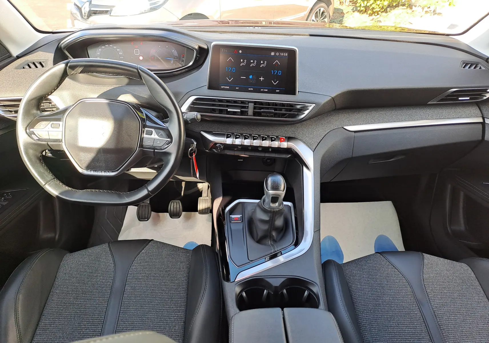 Vue intérieure avant du Peugeot 3008 2019 avec tableau de bord moderne, volant compact et sièges tissu cuir gris.