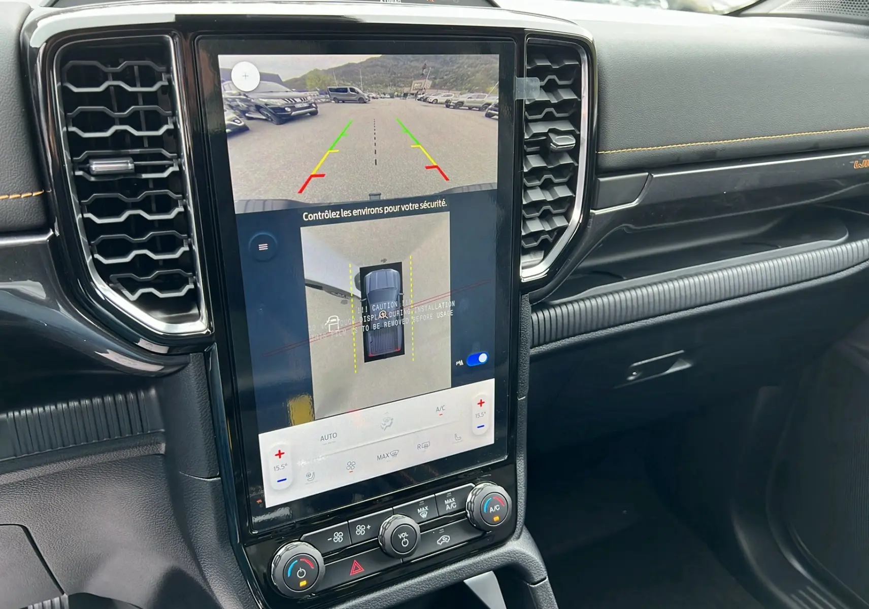 Vue rapprochée de l'écran central tactile du Ford Ranger Wildtrak Plus blanc glacier 2025 avec caméra de recul affichée.