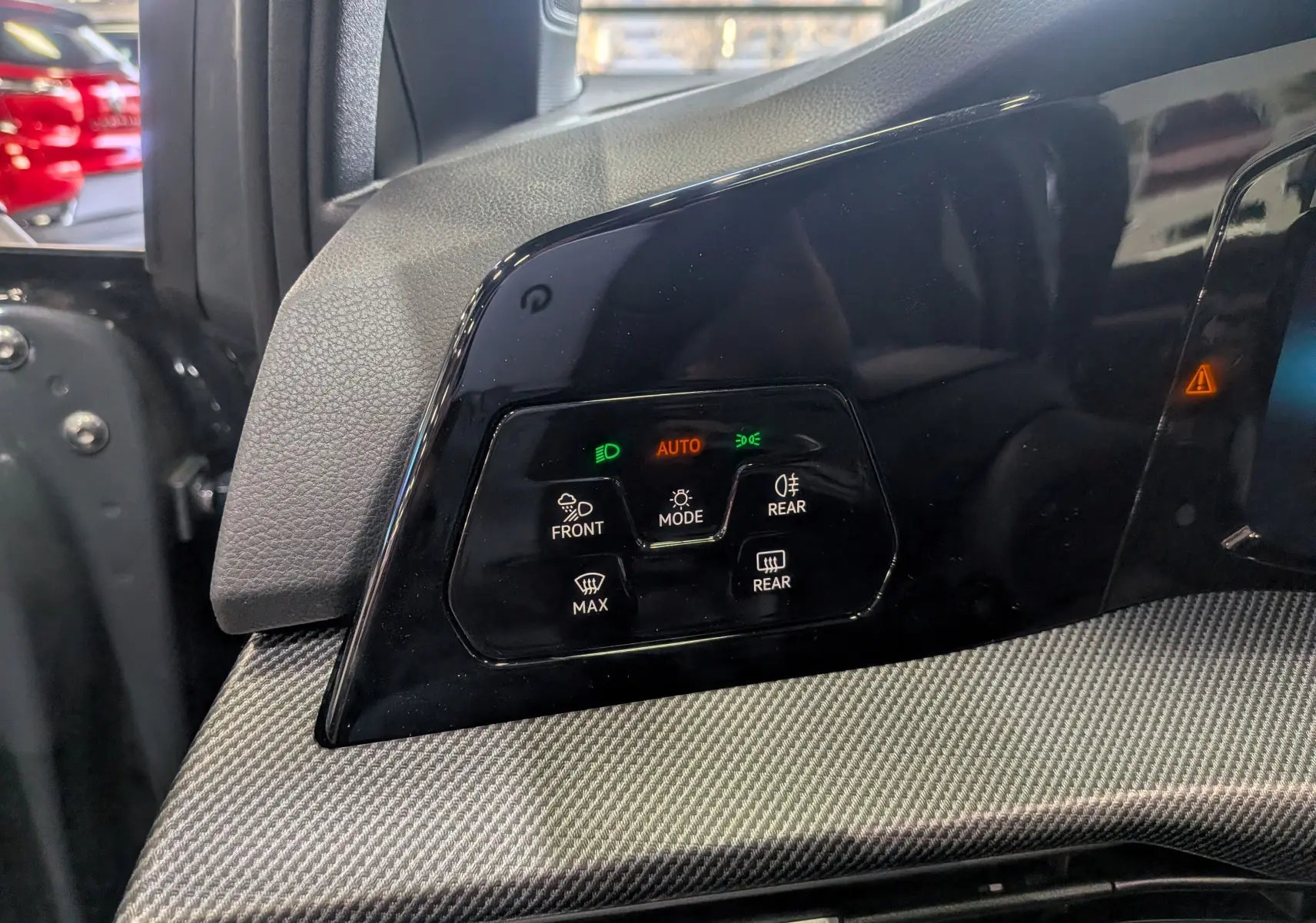 Panneau de commandes d’éclairage avec mode automatique sur tableau de bord gris d’une Volkswagen Golf 2025.