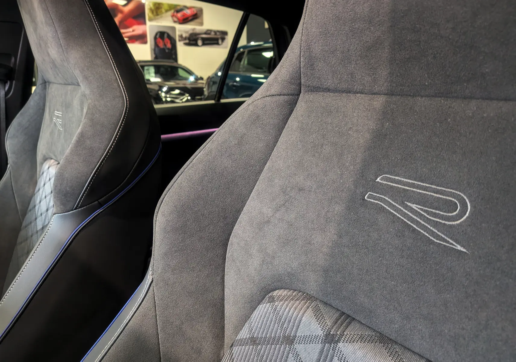 Gros plan sur les sièges avant en alcantara gris avec logo R brodé, intérieur de Volkswagen Golf 1.5 eTSI 2025.