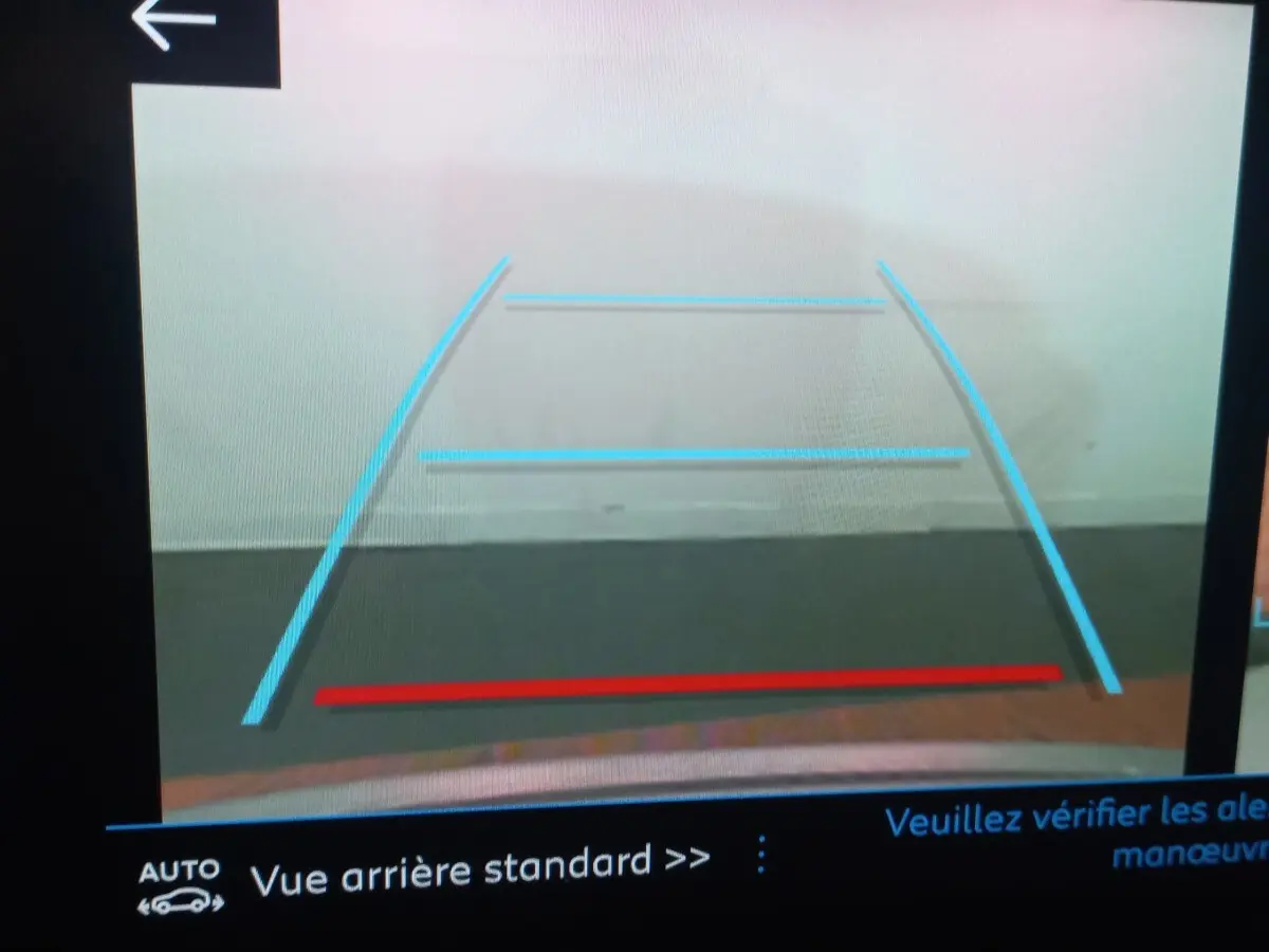 Vue arrière caméra de recul du Peugeot 3008 gris clair, avec lignes de guidage bleues et rouge visibles à l'écran.