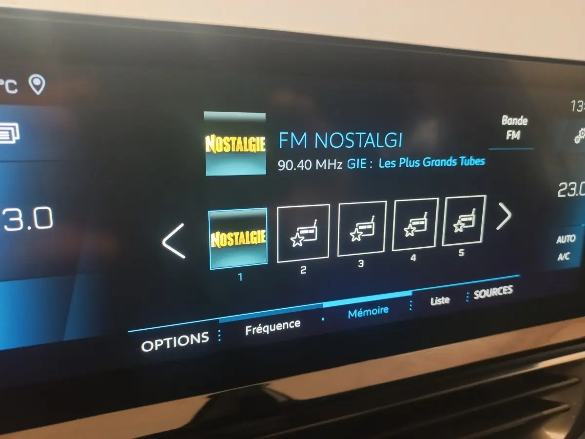 Écran tactile central du Peugeot 3008 gris clair, affichant la radio FM Nostalgie en mode multimédia.