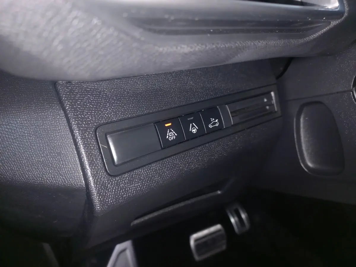 Gros plan sur les boutons de commande d'aide à la conduite dans l'habitacle noir du Peugeot 3008 GT gris clair.