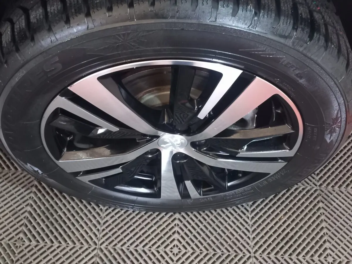 Gros plan sur la jante alliage bicolore noire et argentée du Peugeot 3008 gris clair, vue de dessus.