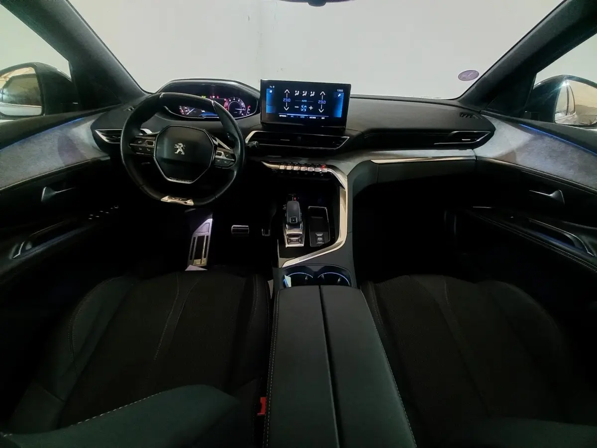 Vue intérieure avant du Peugeot 3008 GT 2022, tableau de bord moderne avec écran tactile central et volant cuir noir.