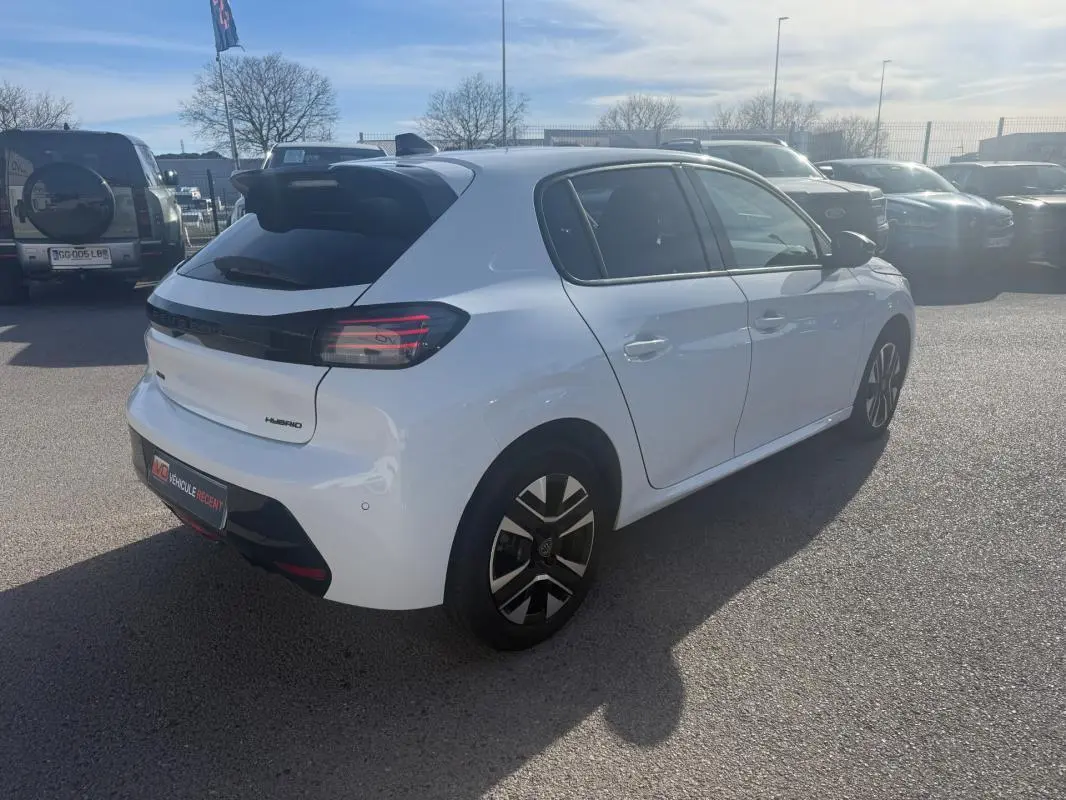 Vue 3/4 arrière droite d'une Peugeot 208 Hybrid 110 e-DCS6 Allure blanche avec feux arrière sombres et jantes stylisées.