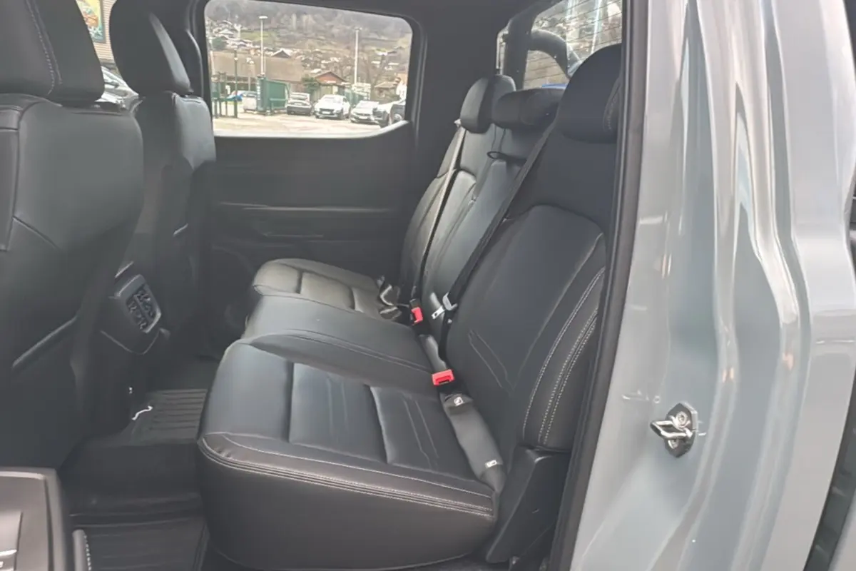 Vue intérieure côté droit des sièges arrière en cuir noir du Ford Ranger gris commandeur avec ceinture de sécurité visible.