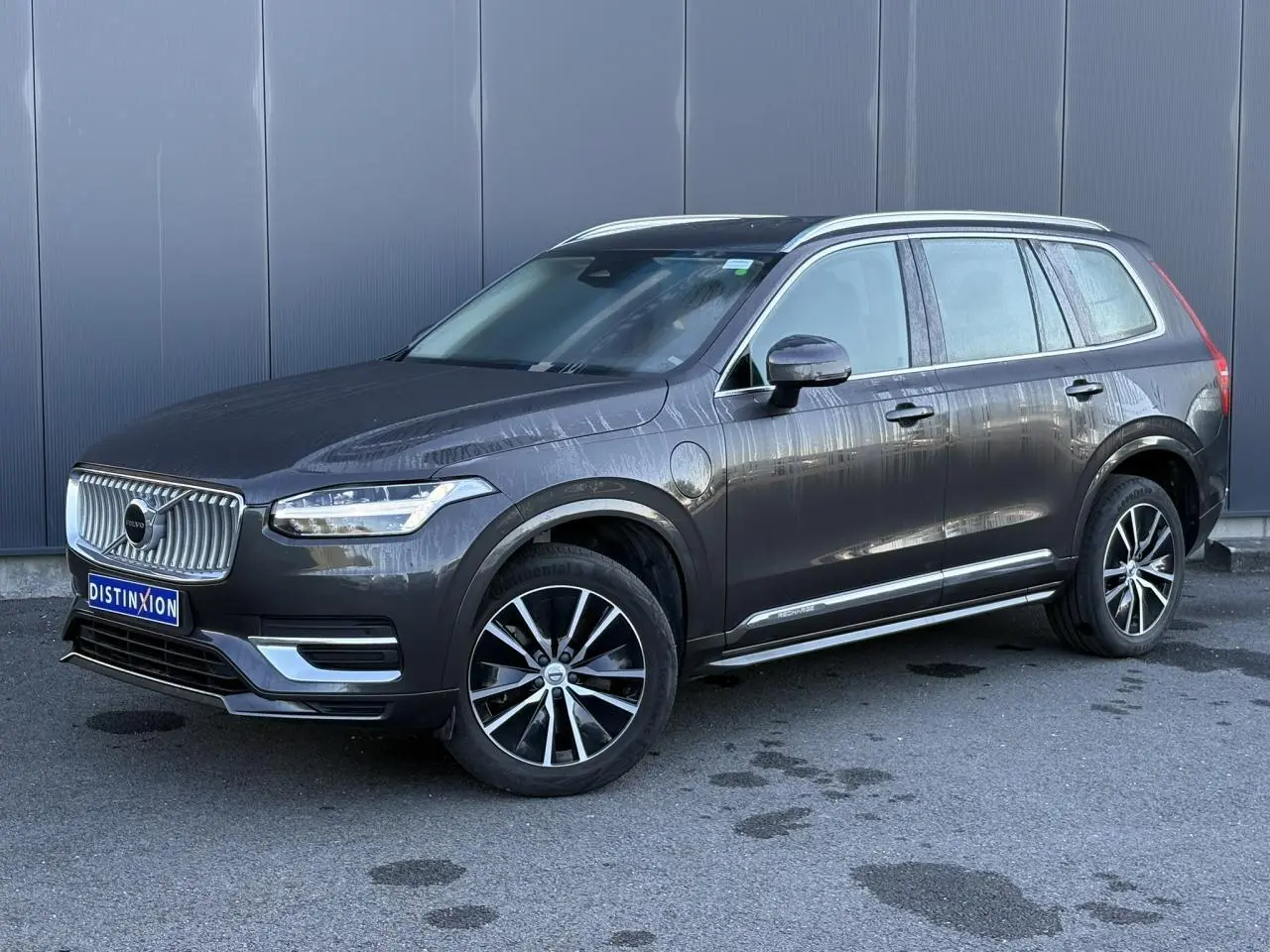 Volvo XC90 T8 hybride gris Platinium en 3/4 avant droit avec jantes alliage et calandre chromée.