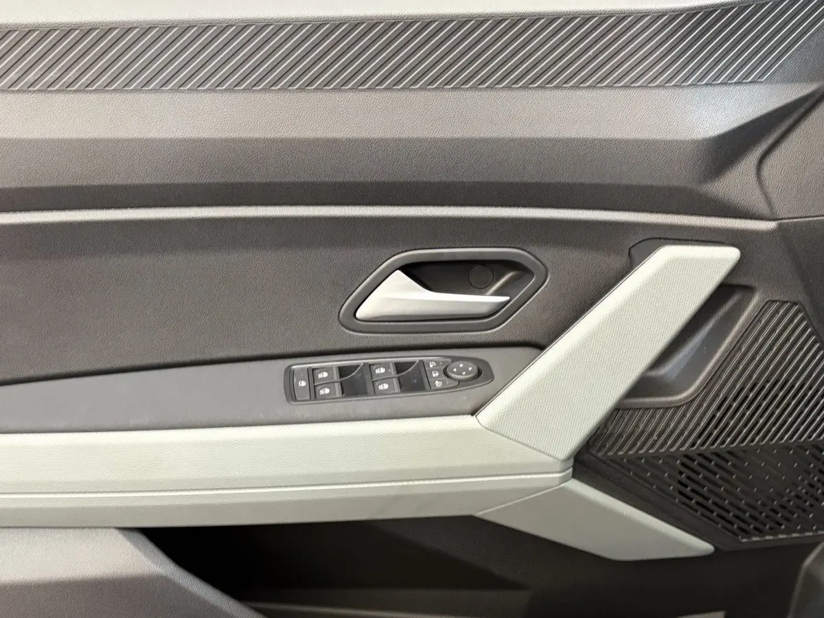 Détail de la porte intérieure côté conducteur du Dacia Duster noir 2025 avec commandes de vitres et poignée argentée.