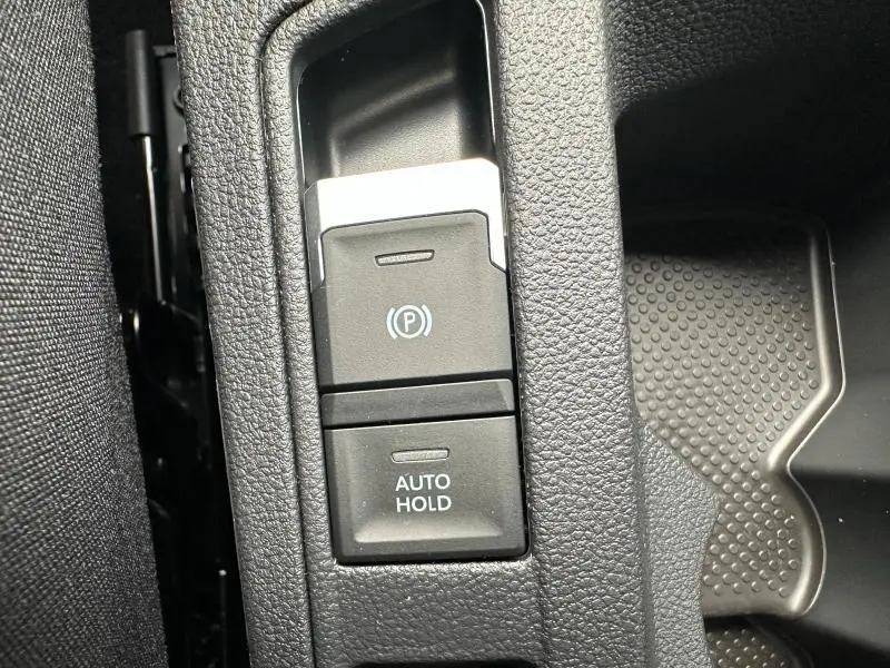 Gros plan sur les commandes de frein de stationnement électrique et Auto Hold dans le Volkswagen T-Roc gris 2025 R-Line Edition.