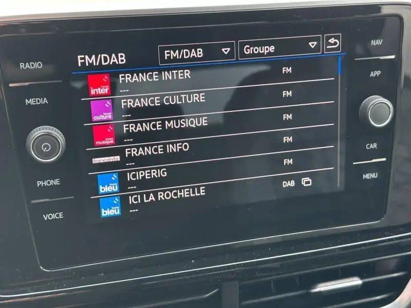 Écran multimédia du Volkswagen T-Roc 2025 affichant les stations FM/DAB avec interface claire et boutons tactiles.