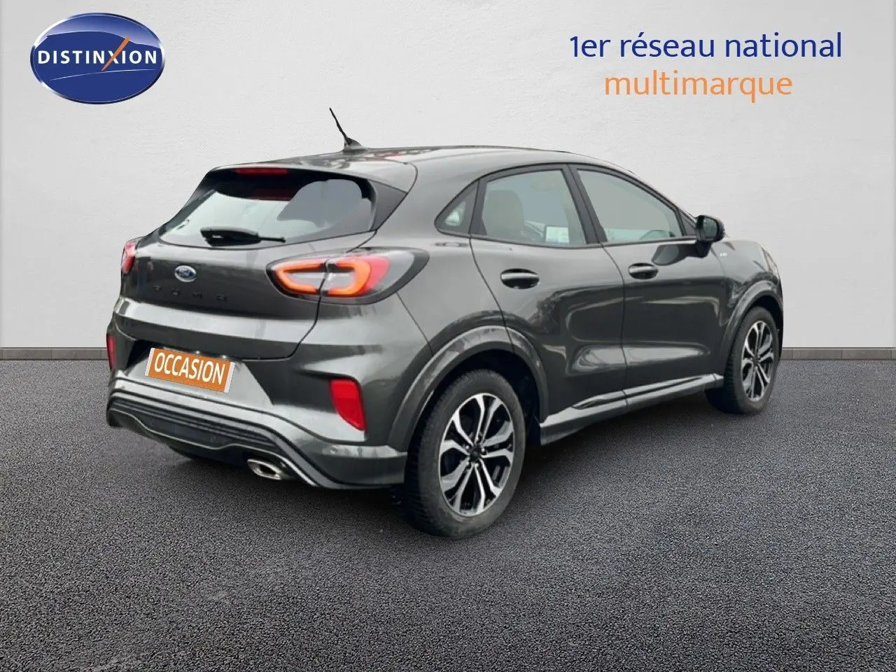 Ford Puma 2024 gris magnétique en vue 3/4 arrière droit, avec feux arrière LED et jantes alliage noires.