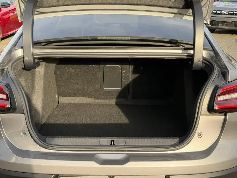 Coffre ouvert vu de l'arrière du Citroën C4 X 2025 gris Mercury, montrant un espace de chargement vide et propre.