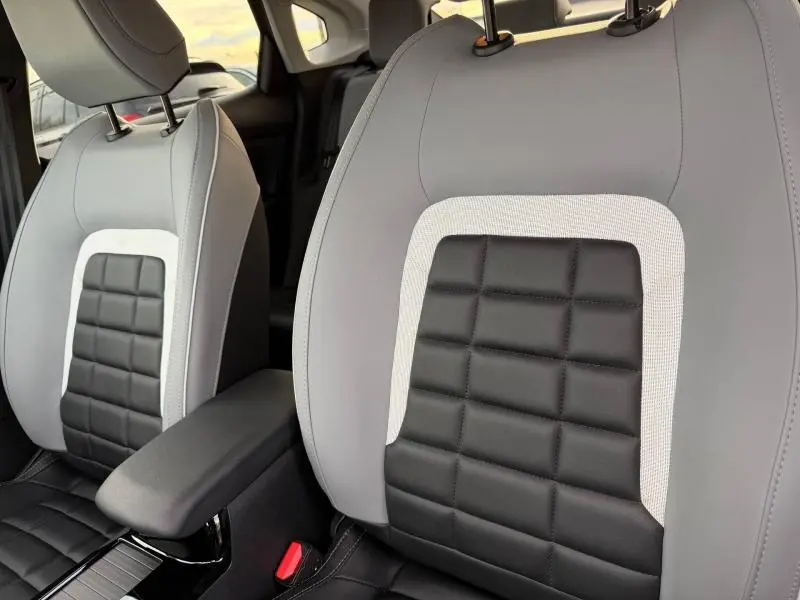 Gros plan sur les sièges avant gris Mercury avec inserts noirs matelassés et surpiqûres blanches du Citroën C4 X 2025.