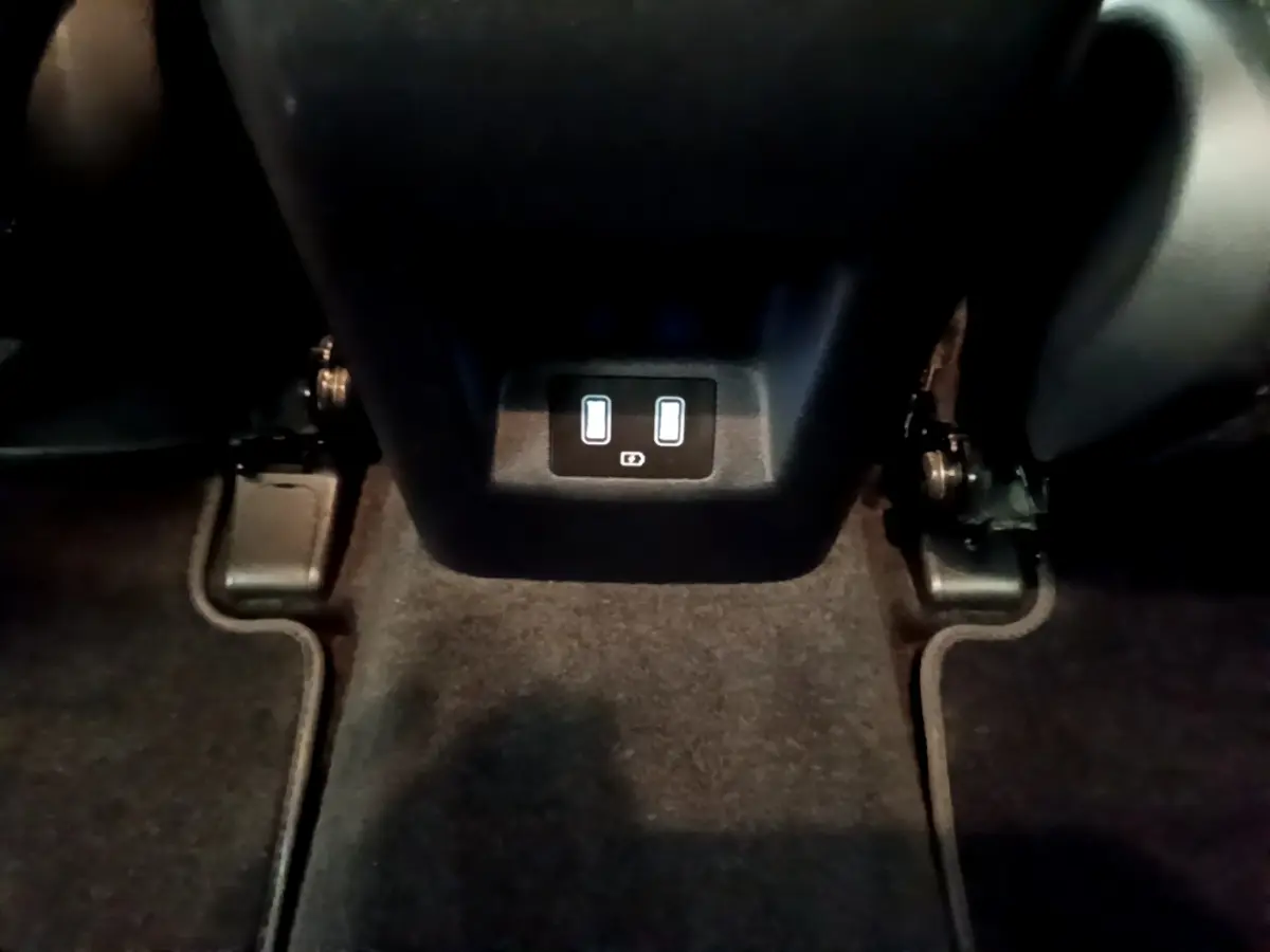 Prise USB double arrière sur console centrale noire du Hyundai Tucson gris foncé 2022, vue intérieure basique.