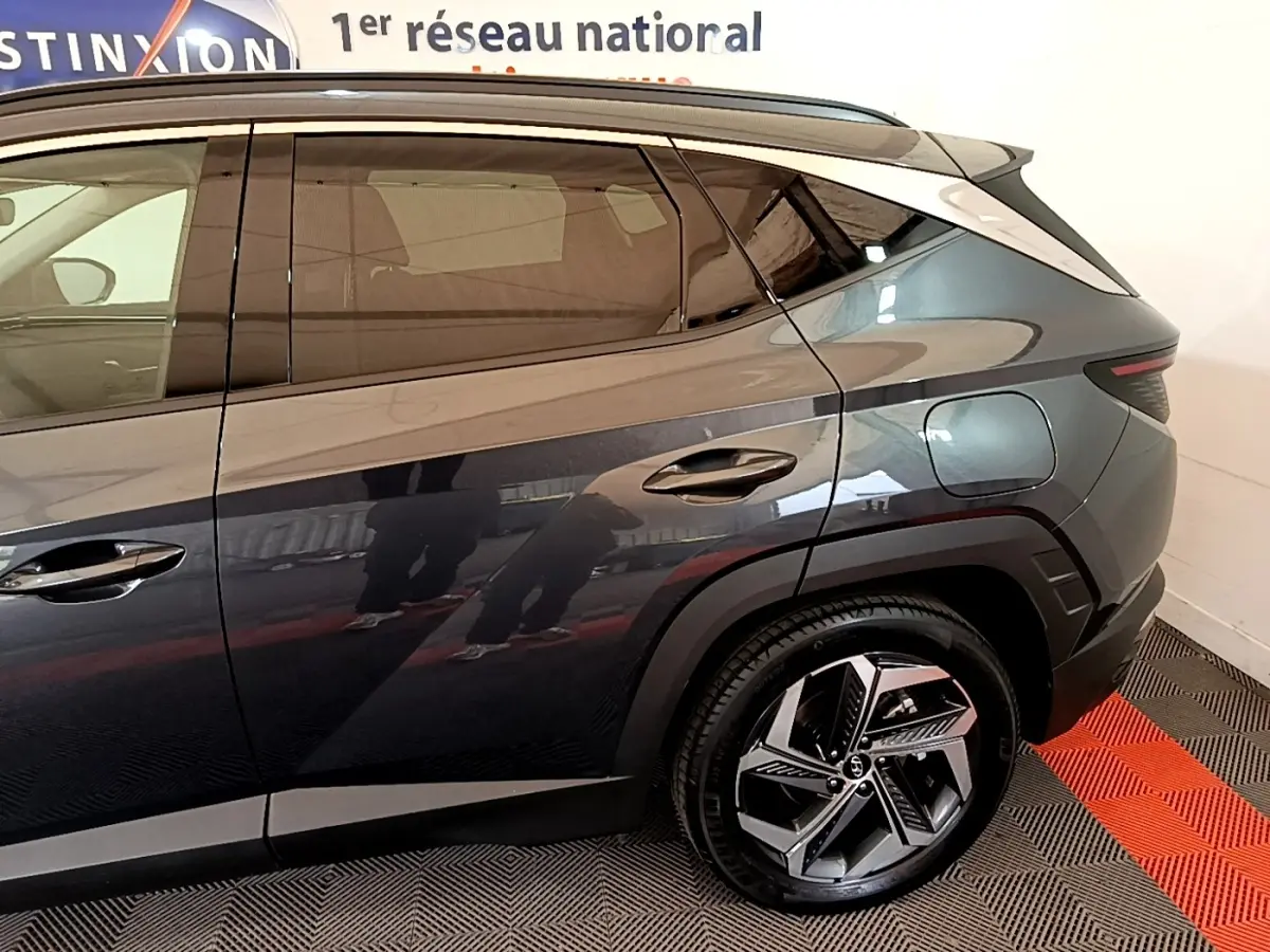 Vue côté droit arrière du Hyundai Tucson gris foncé 2022, mettant en valeur la porte arrière et la roue au design moderne.