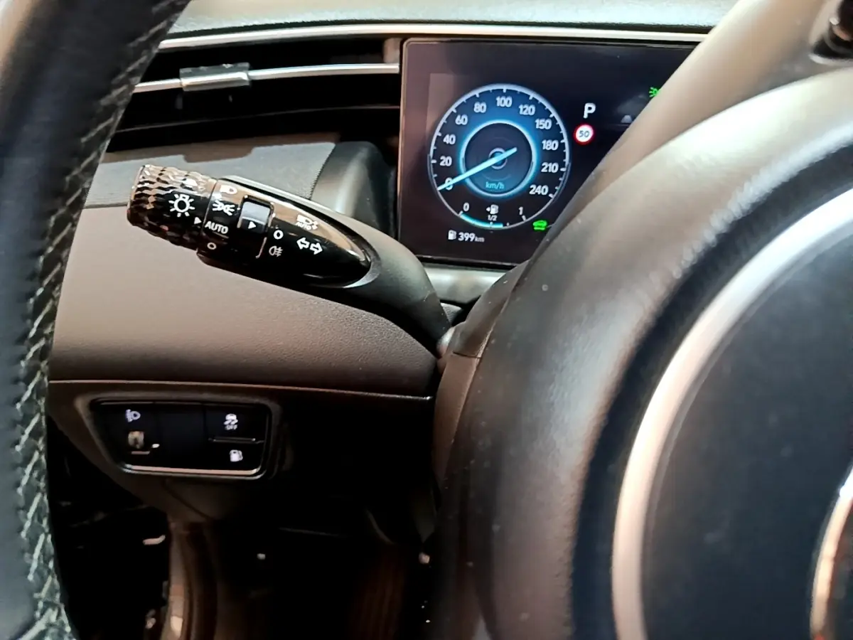 Vue rapprochée du tableau de bord du Hyundai Tucson 2022, affichage digital du compteur et commande des phares.