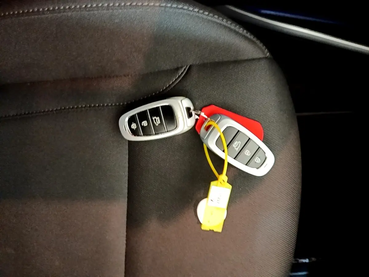 Gros plan sur deux clés de voiture Hyundai posées sur un siège tissu noir, sans vue du véhicule.