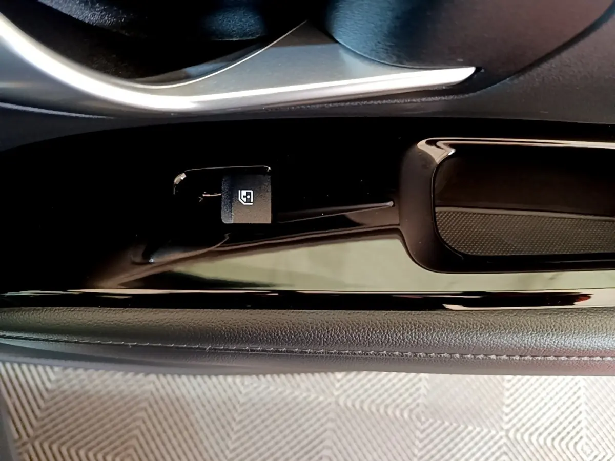 Détail de la commande d'ouverture du coffre sur la porte côté conducteur du Hyundai Tucson gris foncé 2022.