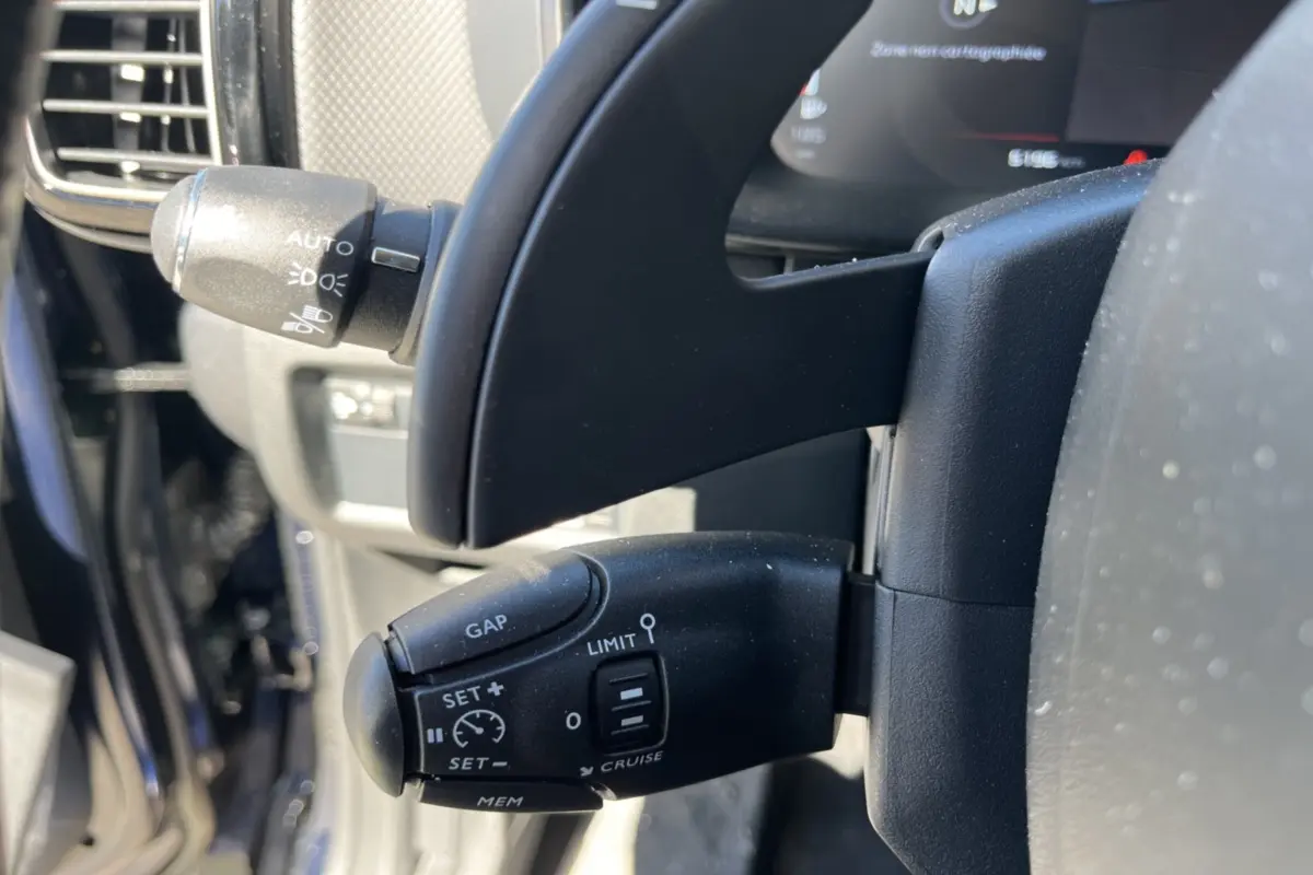 Gros plan sur la commande de régulateur de vitesse au volant d’un Citroën C5 Aircross Bleu Eclipse 2025.